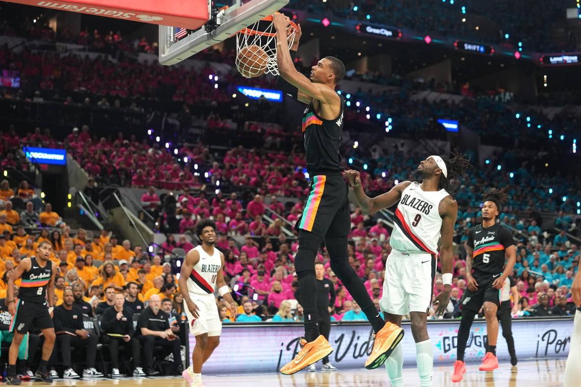  Apr 19, 2026; San Antonio, Texas, USA; San Antonio Spurs forward Victor Wembanyama (1) dunks ahead of Portland Trail Blazers forward Jerami Grant (9) during the first half of game one of the first round of the 2026 NBA Playoffs at Frost Bank Center. Mandatory Credit: Scott Wachter-Imagn Images 
