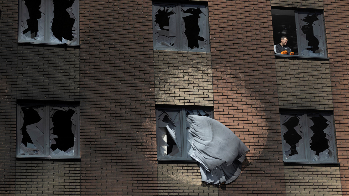 A man clears broken glass at an apartment building that was damaged during a night of Russian missile and drone strikes, amid Russia's attack on Ukraine, in Shchaslyve, outside Kyiv, Kyiv region, Ukraine May 14, 2026. REUTERS/Thomas Peter