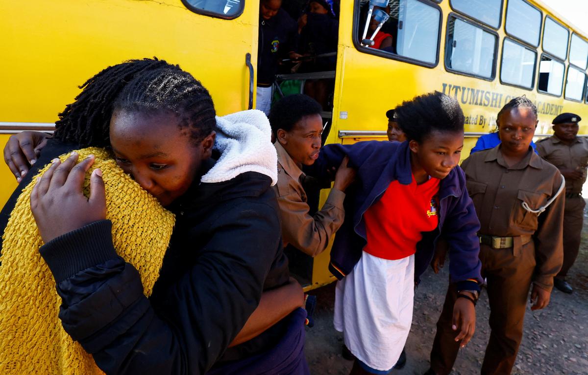 A student injured in a stampede is assisted as she disembarks from the school bus at the Utumishi Girls' Academy Senior School following an overnight fire in a dormitory at the facility in Gilgil, Nakuru county, Kenya May 28, 2026. REUTERS/Thomas Mukoya