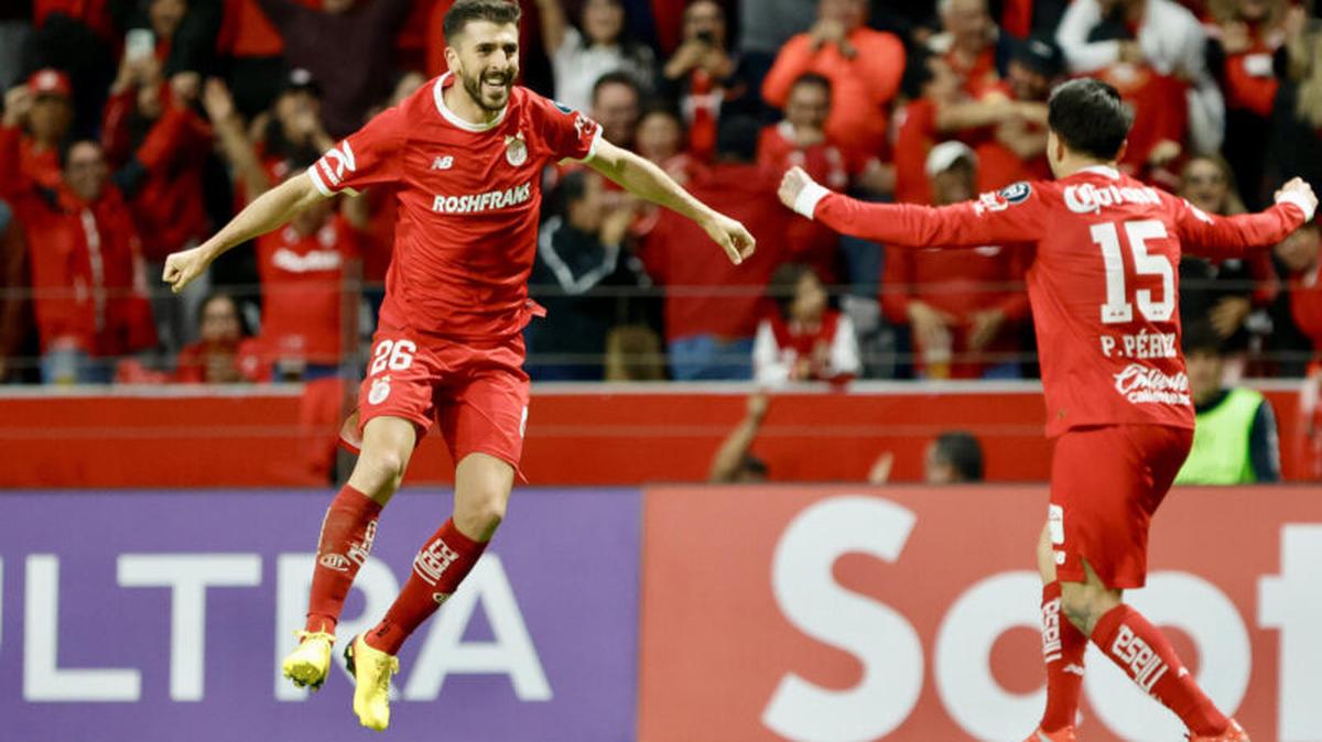 Joao Dias (i) y Pavel Pérez del Toluca celebran un gol este miércoles, durante un partido de la semifinal de la Copa de Campeones Concacaf en el estadio Nemesio Diez en Toluca (México). EFE/Felipe Gutiérrez
