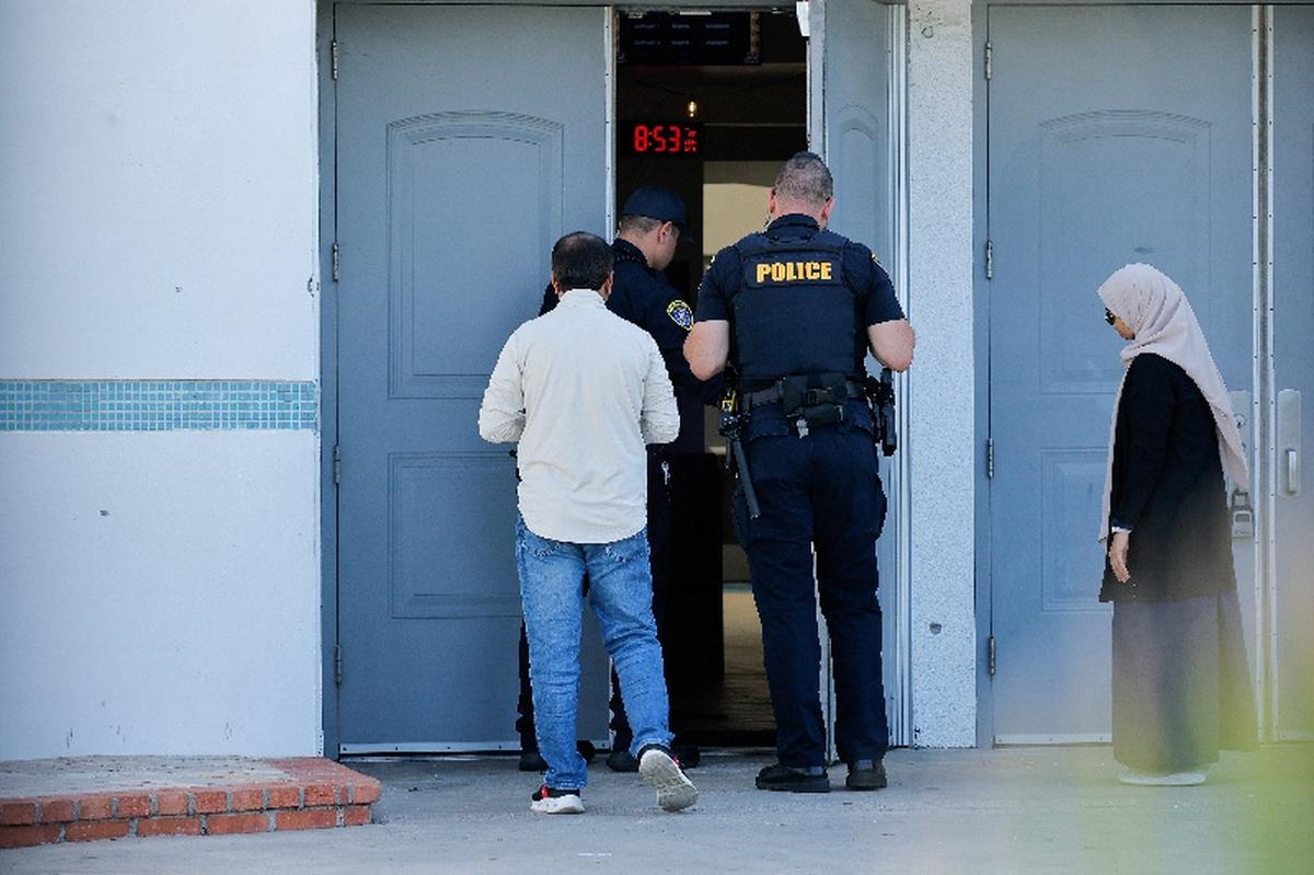 Police officers allow people to enter Islamic Centre of San Diego, the morning following a shooting, in San Diego, California, U.S, May 19, 2026.  REUTERS/ Mike Blake