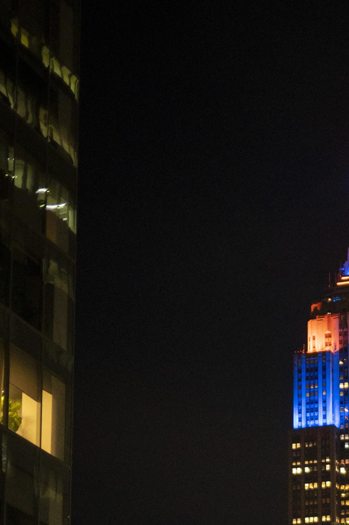 The Empire State Building in Manhattan is lit up in the home team's colors after the New York Knicks swept the Cleveland Cavaliers in the Eastern Conference Finals to advance to the NBA Finals for the first time since 1999 on Monday night, May 25, 2026. Thousands of fans blocked traffic outside Madison Square Garden, even though the game was in Ohio and the outdoor watch parties at the Garden had been suspended because of rowdy fans. (Vincent Alban/The New York Times)