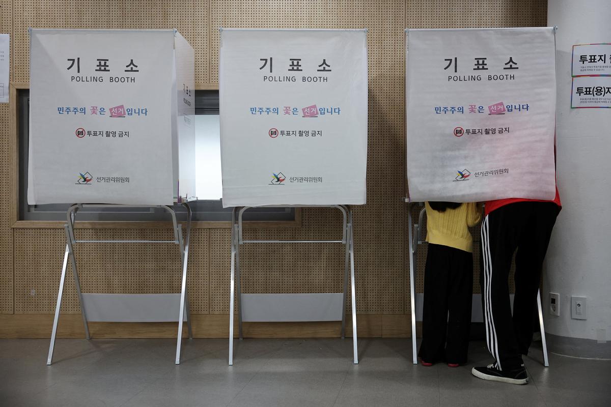A man votes with his daughter during the local elections at a polling station, in Seoul, South Korea, June 3, 2026.    REUTERS/Kim Hong-Ji