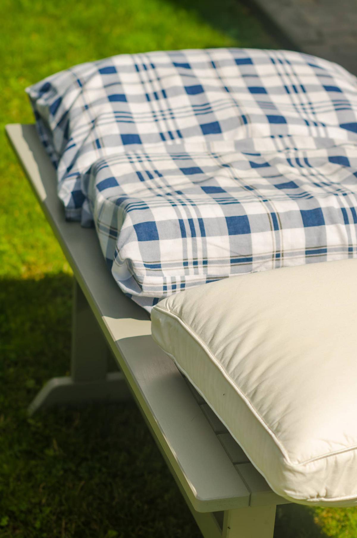  colourful pillows drying in the sun on the lawn on a bench . High quality photo.