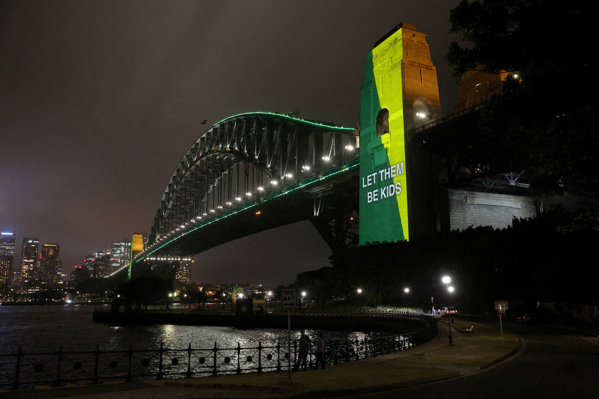FILE PHOTO: A message the reads ‘Let them be kids’ is projected onto the Sydney Harbour Bridge to mark a law banning social media for users under 16 in Australia in Sydney, Australia, December 10, 2025. REUTERS/Hollie Adams/File Photo