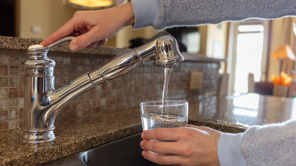 Drinking water. A stock image of a person filling a glass with tap water for drinking.