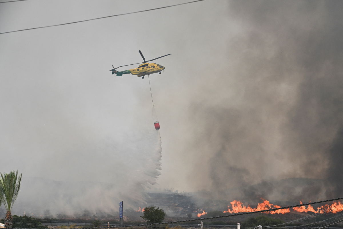 A firefighting plane dumps water during deadly wildfires affecting Almeria province, in Alfaix, Spain, July 10, 2026. REUTERS/Stringer
