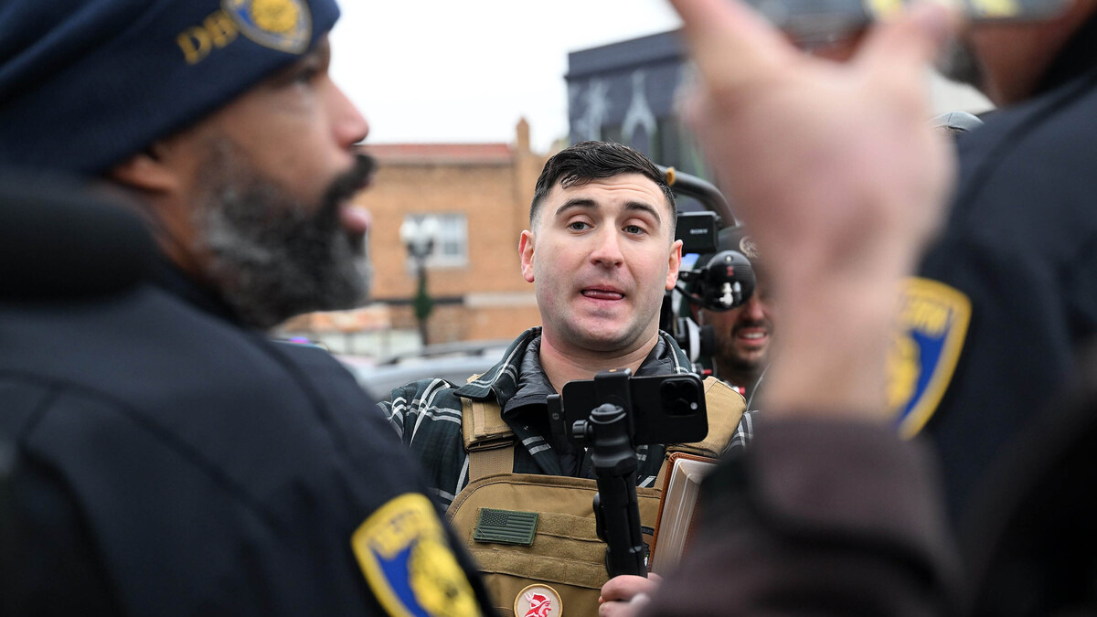 Jake Lang, man pardoned by President Trump on charges from Jan. 6, 2021, tries to get Dearborn Police officers to arrest a man he claims pushed him as groups demonstrate on both sides of Michigan Avenue in 2025 in Dearborn, Michigan. (Robin Buckson/The Detroit News/TNS)