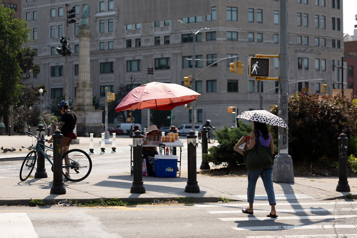 A woman crosses the street in New York City, U.S. July 1, 2026. REUTERS/Jordan Tovin