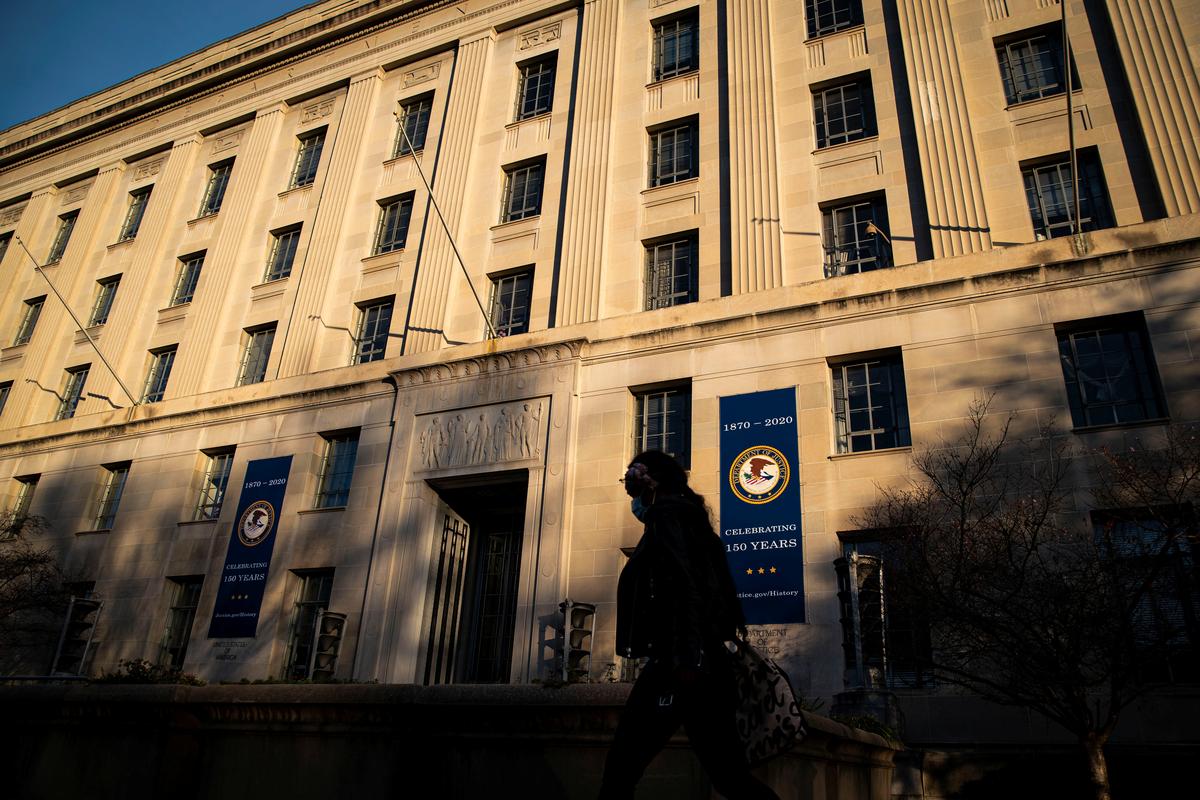 A woman walks past the U.S. Department of Justice Building, in Washington, U.S., December 15, 2020. REUTERS/Al Drago