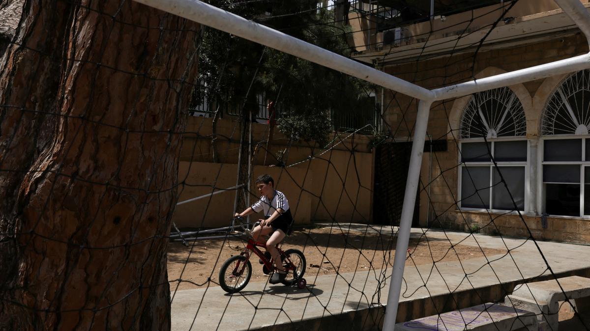 FILE PHOTO: A child rides a bicycle in Hariri High School II, used as a temporary shelter for displaced people, in Beirut, Lebanon, May 2, 2026. REUTERS/ Raghed Waked/File Photo