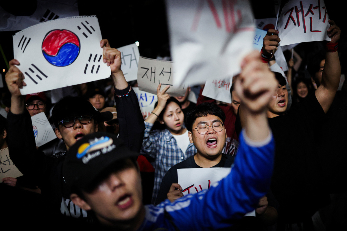 Demonstrators hold signs reading, "Rerun election", as people surround a vote-counting centre to protest a controversy over a shortage of ballot papers that disrupted voting in the local election and to call for a rerun of the election, in Seoul, South Korea, June 6, 2026. REUTERS/Kim Hong-Ji