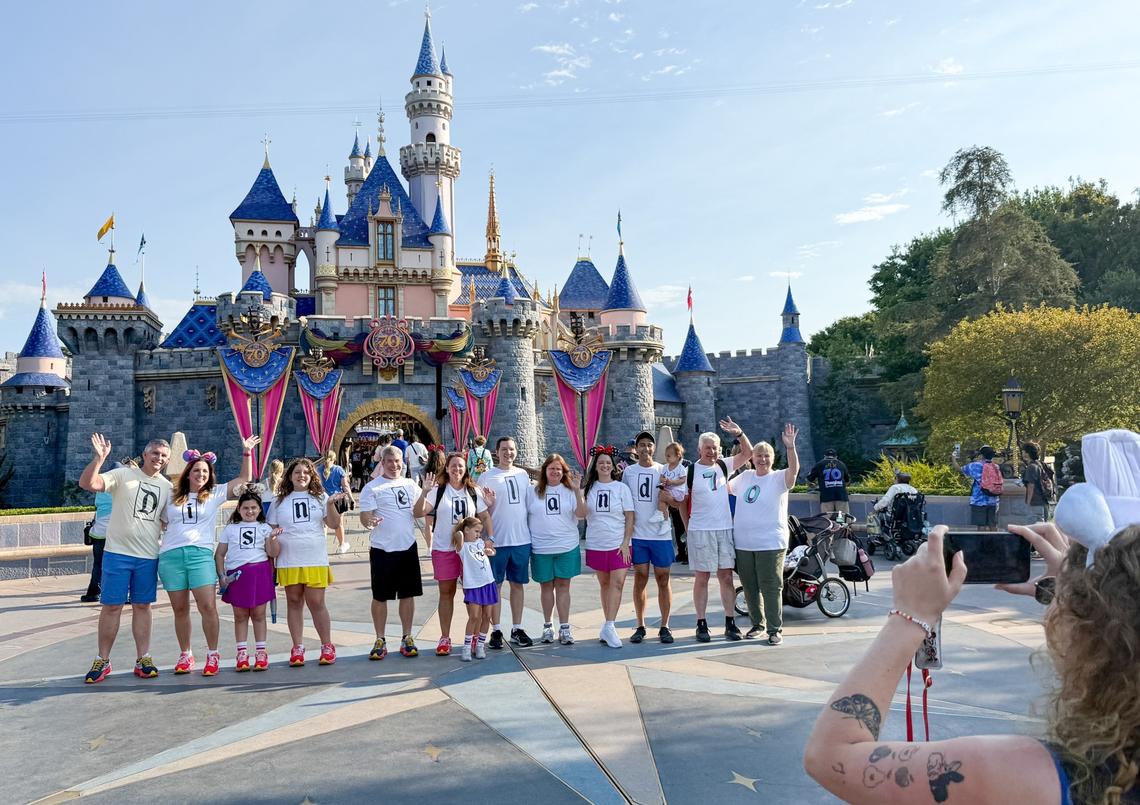 Visitors to Disneyland take a family photo in front of Sleeping Beauty castle during the 70th anniversary of Disneyland on July 17, 2025, in Anaheim.