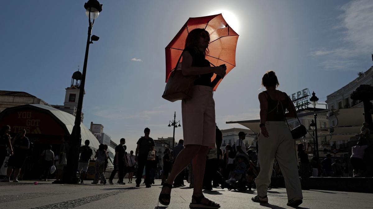 A woman with an umbrella walks at Plaza Puerta del Sol during a spring heatwave in Madrid on Wednesday. Average global temperatures are forecast to reach near-record levels in the next five years, with Arctic temperatures expected to warm faster than other regions, a report said on Thursday.