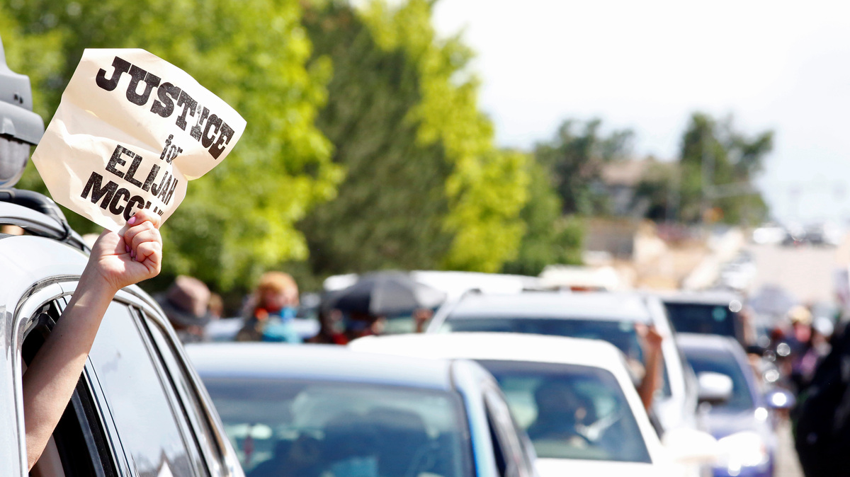 A driver holds a sign out of her car window that reads ?Justice for Elijah McClain? during a protest against the death of McClain and police injustice in Aurora, Colorado, U.S., June 27, 2020.  REUTERS/Kevin Mohatt