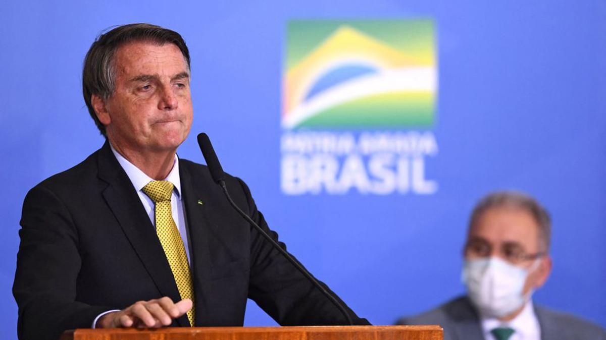 Then Brazilian President Jair Bolsonaro, left, speaks near Health Minister Marcelo Queiroga during the launching ceremony of a new registry of professional fishermen, at Planalto Palace in Brasilia on June 29, 2021. Brazilian Supreme Court Justice Alexandre de Moraes suspended the application of legislation that would reduce the amount of time former President Bolsonaro and others will serve for plotting a coup attempt, according to a ruling released on Saturday, May 9, 2026. (Evaristo Sa/AFP via Getty Images/TNS)