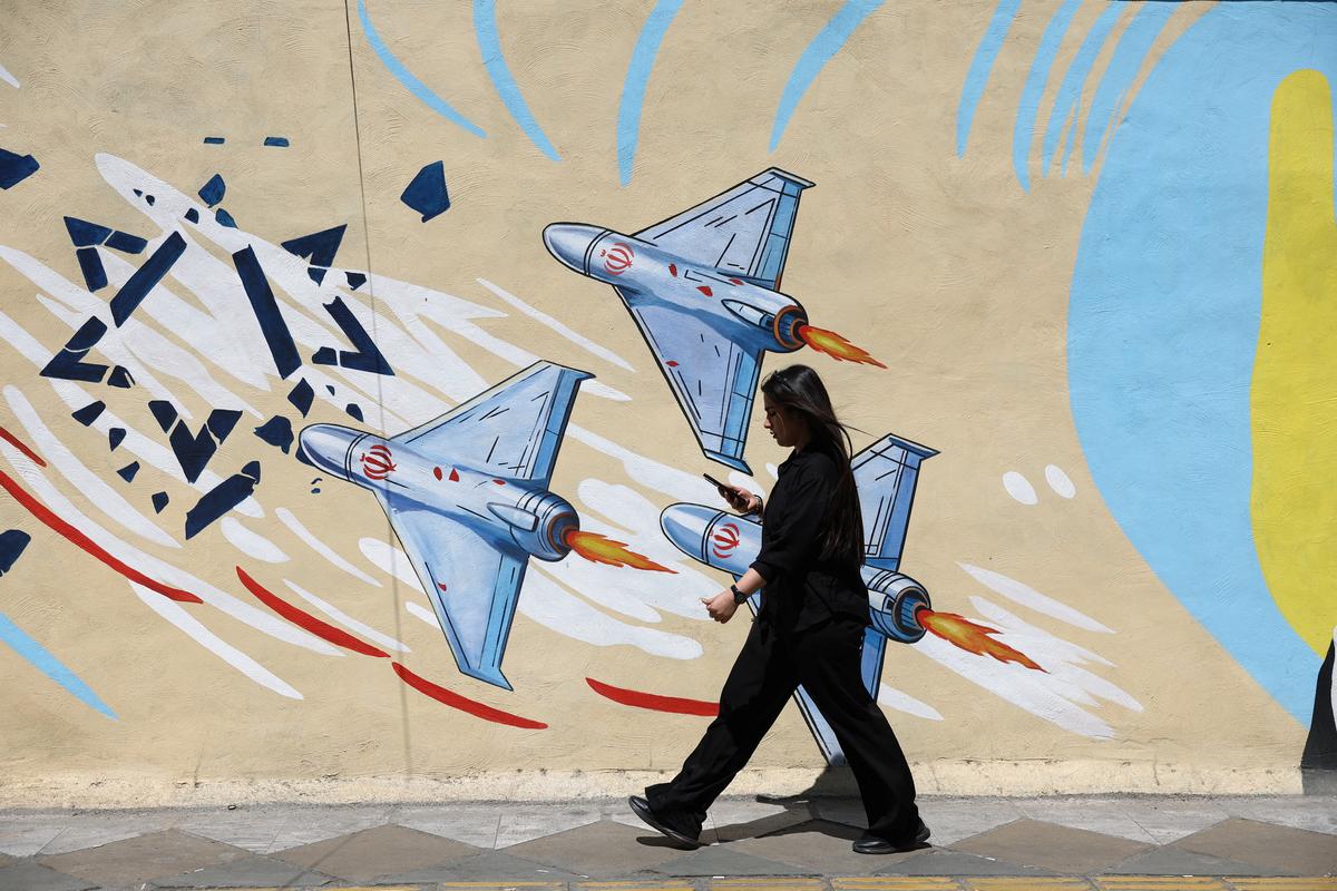 An Iranian woman walks next to an anti-Israeli mural on a street in Tehran, Iran, May 11, 2026. Majid Asgaripour/WANA (West Asia News Agency) via REUTERS