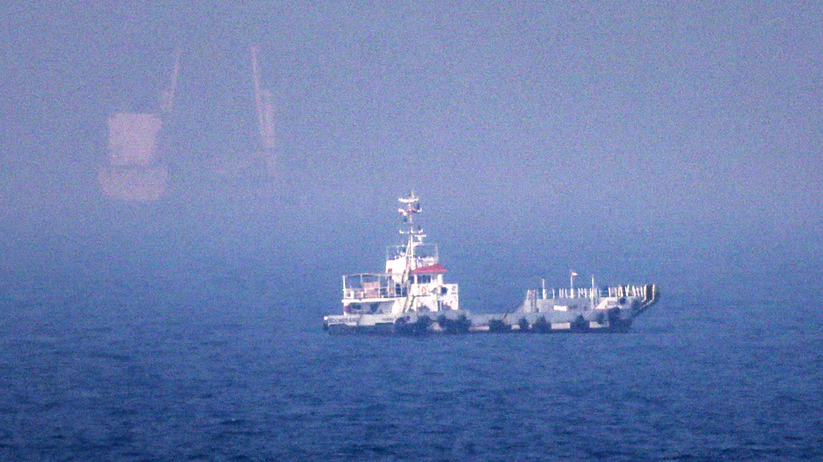 Ships sail near the Strait of Hormuz off the eastern coast of the United Arab Emirates at Khor Fakkan on July 13, 2026. The United States is "taking over" the Strait of Hormuz and will be paid for protecting it, President Donald Trump declared on July 13, as Washington and Tehran once again fought over the vital waterway.