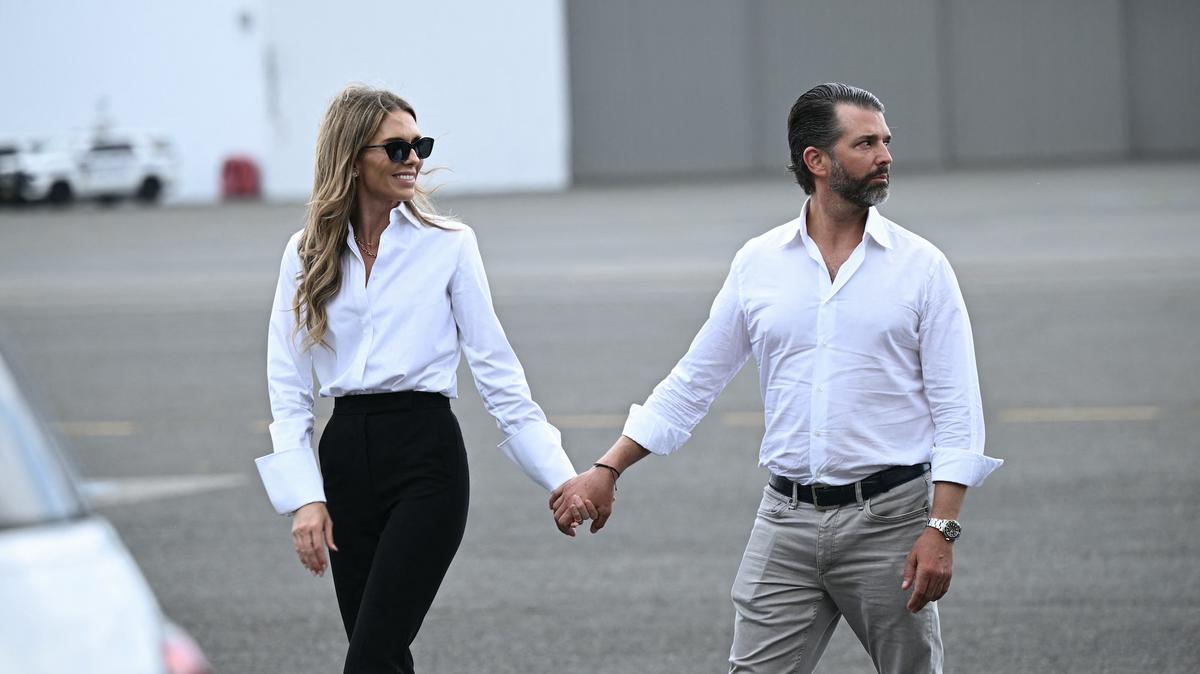 Donald Trump Jr. and Bettina Anderson walk on the tarmac as they await the arrival of President Donald Trump and First Lady Melania Trump at Teterboro Airport in Teterboro, New Jersey, on July 13, 2025.