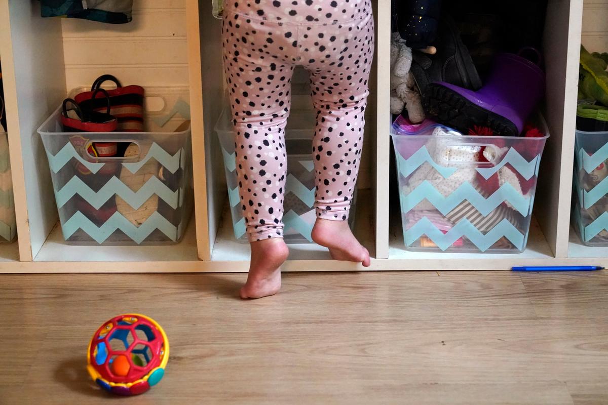 A preschooler gets up on her toes to reach into her assigned cubby at a preschool center Monday, Oct. 25, 2021, in Mountlake Terrace, Wash. Child care centers once operated under the promise that it would always be there when parents have to work. Now, each teacher resignation, coronavirus exposure, and day care center closure reveals an industry on the brink, with wide-reaching implications for an entire economy’s workforce.