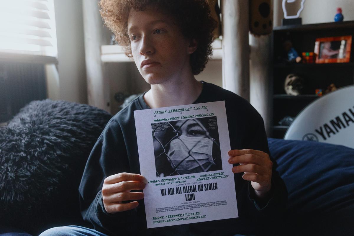  Jordan Comfort, a high school junior, holds the flyer he handed out that led to his assignment to a DAEP in Garland, Texas. Students all over North Texas were planning a walkout to protest Immigration and Customs Enforcement, and Comfort was one of several students handing out flyers for the one at his school in Garland. Credit: Shelby Tauber for The Hechinger Report