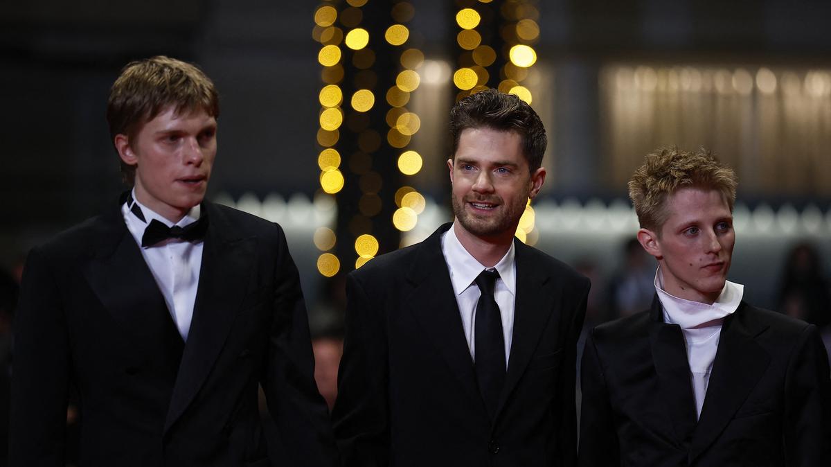 Director Lukas Dhont, cast members Emmanuel Macchia and Valentin Champagne pose on the red carpet during arrivals for the screening of the film "Coward" in competition at the 79th Cannes Film Festival in Cannes, France, May 21, 2026. REUTERS/Sarah Meyssonnier