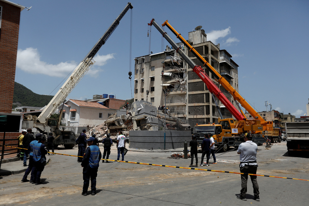Emergency services work at the site of a collapsed building following earthquakes that hit the country, in Caracas, Venezuela, June 26, 2026. REUTERS/Fausto Torrealba