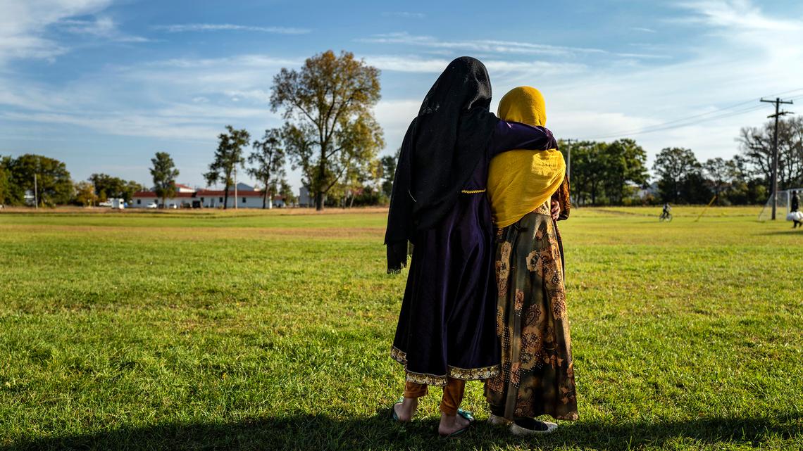 Afghan refugee girls watch a soccer match near where they are staying in the Village at the Ft. McCoy US Army base on Sept. 30, 2021, in Ft. McCoy, Wisconsin. There are approximately 12,600 Afghan refugees being cared for at the base under Operation Allies Welcome. The Department of Defense, through US Northern Command and US Army North, and in support of the Department of Homeland Security, is providing transportation, temporary housing, medical screening and general support for at least 50,000 Afghan evacuees at suitable facilities in permanent or temporary structures while the Afghans complete the processing necessary to resettle in the United States. (Barbara Davidson/Pool/AFP/Getty Images/TNS)