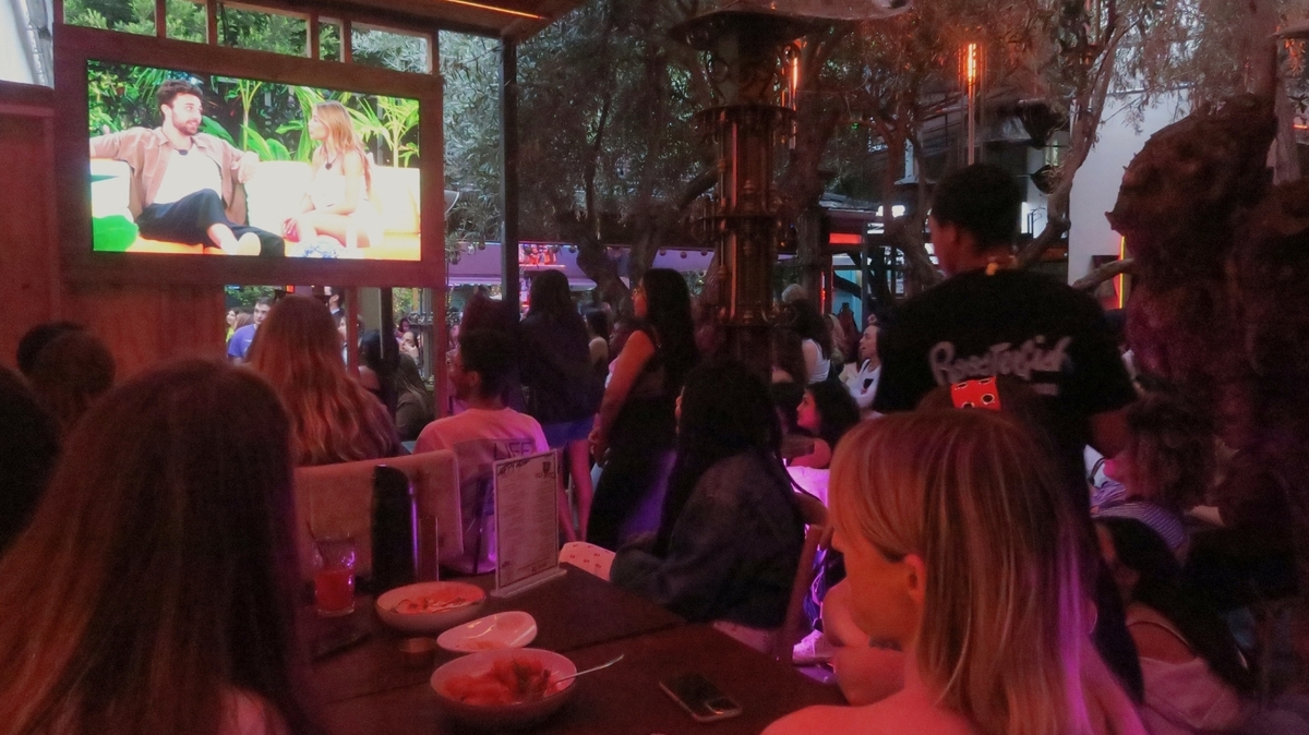 Attendees watch as Los Angeles local, Iris Kendall, connects with fellow islander Zac Woodworth on Love Island USA while attending a watch party at Roosterfish in West Hollywood on Tuesday, June 24, hosted by Reality Bar. (Photo by Carolyn Burt, SCNG)