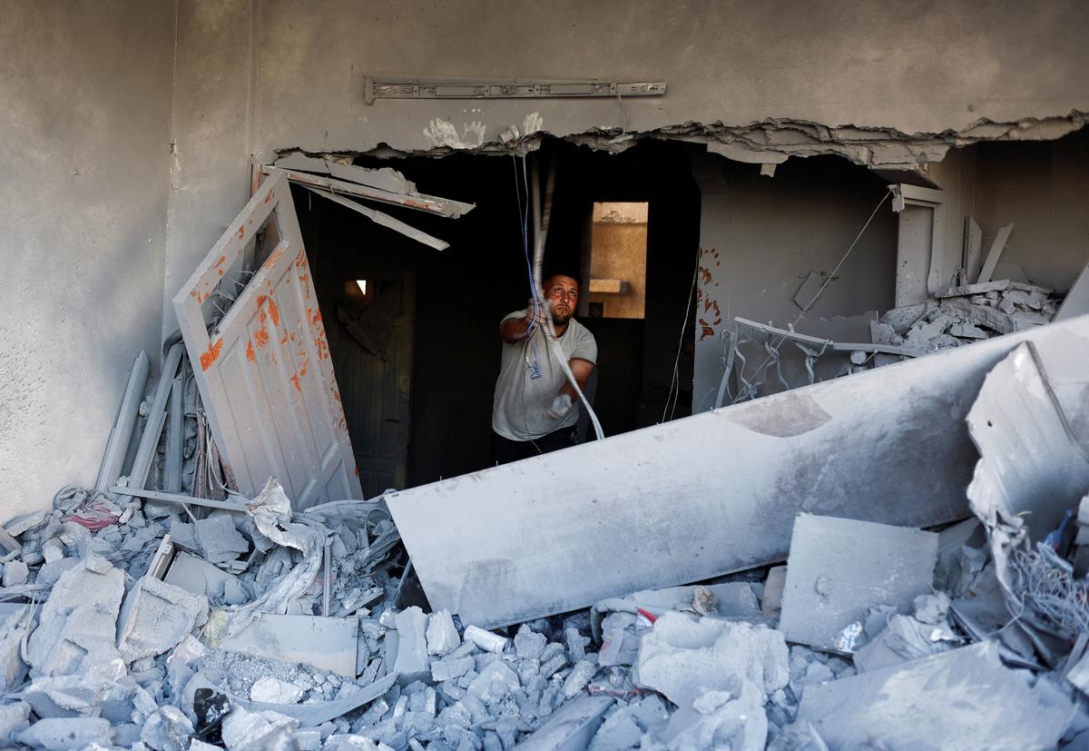 A Palestinian man inspects the site of an Israeli strike on a house that was pre-warned by the Israeli military to evacuate before the strike was carried out late on Saturday, in Deir al-Balah, in the central Gaza Strip, May 24, 2026. REUTERS/Mahmoud Issa