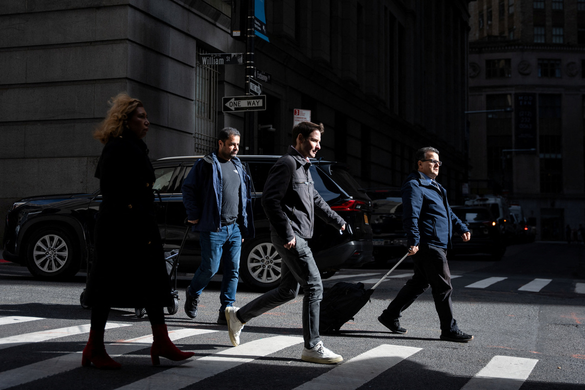 People walk around the Financial District in New York City, U.S., November 5, 2025. REUTERS/Angelina Katsanis
