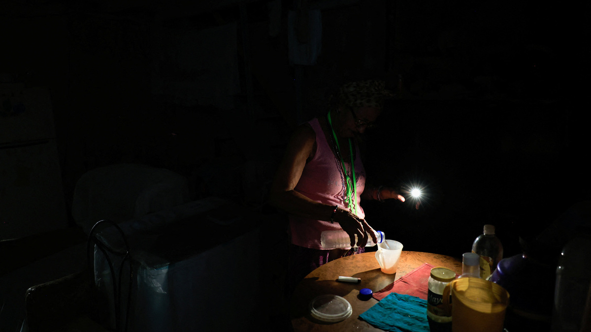 Retired nursing assistant Ana Amelia Gracias, 70, pours water at home as Cuba's national electric grid collapsed at midday, leaving around 10 million people without power, in Havana on Monday.