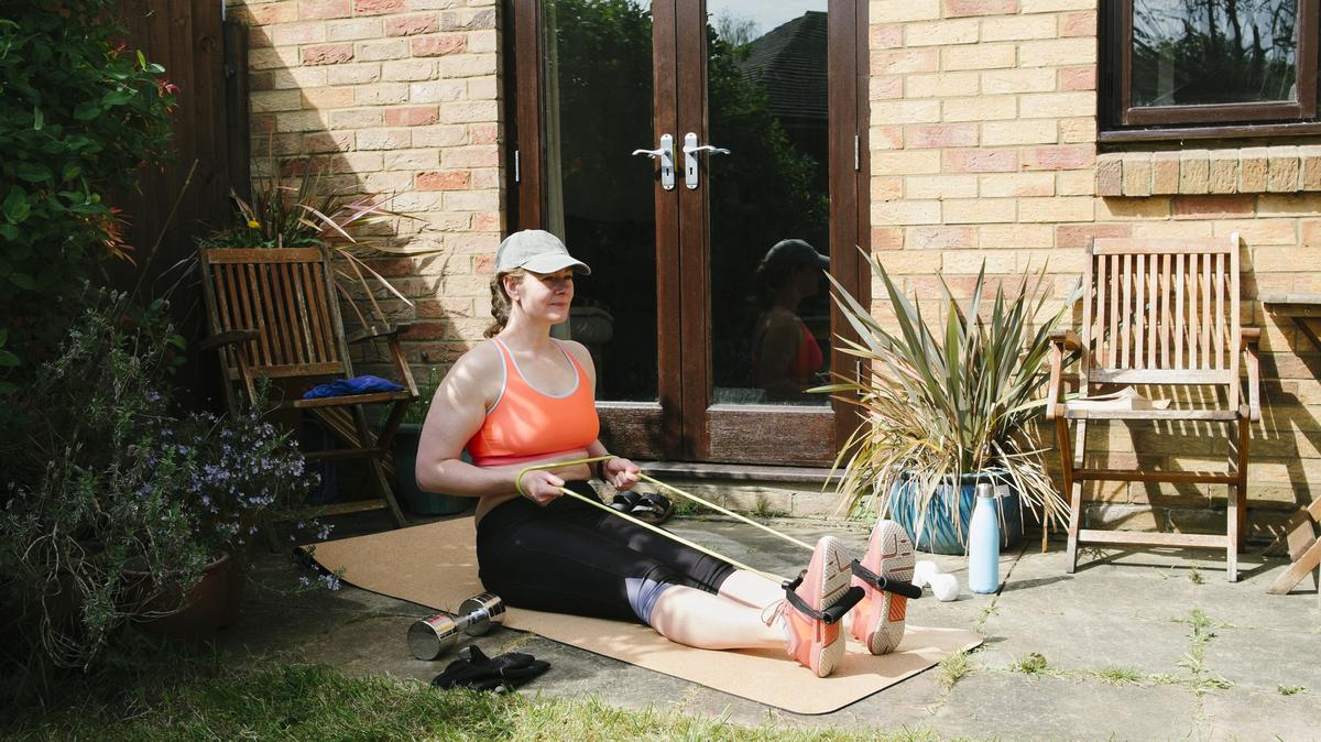 UK, Essex, woman exercising at home in the garden