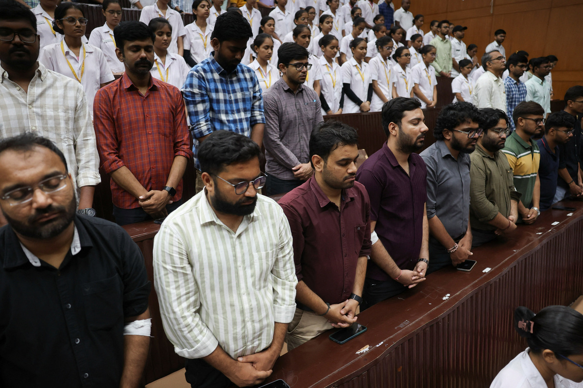 People observe a moment of silence as they attend the memorial ceremony during the first anniversary of Air India Boeing 787-8 Dreamliner crash on June 12, 2025, at B.J. Medical College and Civil hospital in Ahmedabad, India, June 12, 2026. REUTERS/Amit Dave