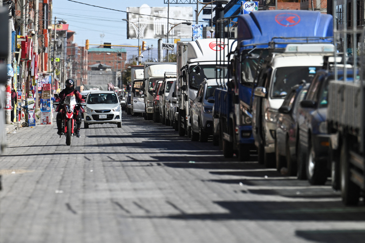 A motorcyclist rides past as vehicles line up to refuel as fuel supplies gradually recover and Bolivia's crisis begins to ease after lawmakers backed the state of emergency, in El Alto, Bolivia, June 21, 2026. REUTERS/Claudia Morales