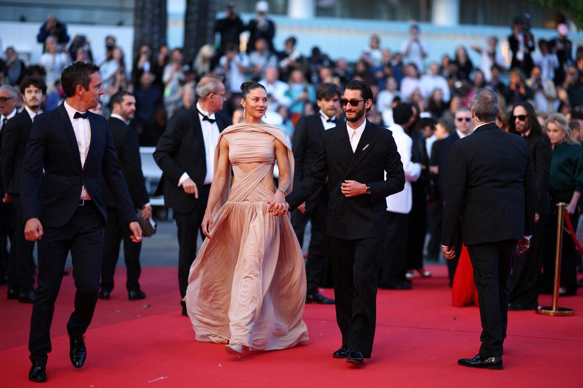 Cast member Pierre Niney and his partner Natasha Andrews pose on the red carpet during arrivals for the screening of the film "Histoires paralleles" (Parallel Tales) in competition at the 79th Cannes Film Festival in Cannes, France, May 14, 2026. REUTERS/Manon Cruz