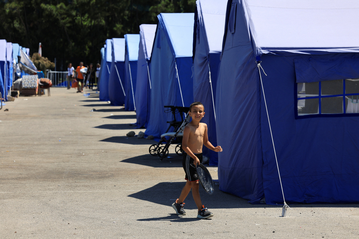 A child walks among tents at a shelter hosting residents displaced from Beirut's southern suburbs, following a deal between the United States and Iran, in Beirut, Lebanon, June 16, 2026. REUTERS/Mohamed Azakir