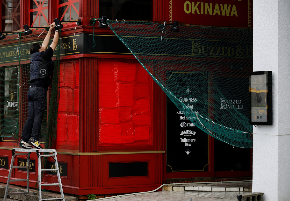 A man installs a wind-proof net to prevent damage from Typhoon Bavi as it approaches in Ishigaki, Japan, July 10, 2026. REUTERS/Kim Kyung-Hoon