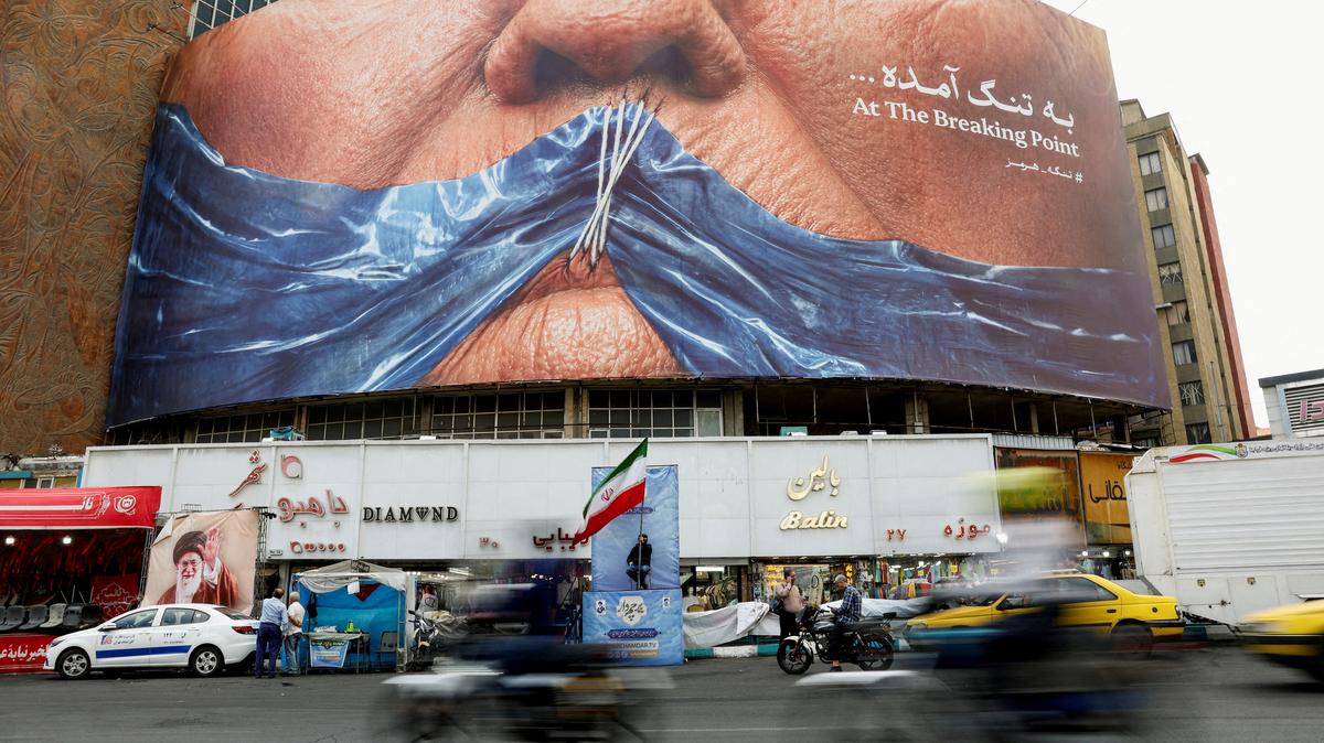 FILE PHOTO: People drive past an anti-U.S. billboard depicting U.S. President Donald Trump and the Strait of Hormuz, in Tehran, Iran, May 17, 2026. Majid Asgaripour/WANA (West Asia News Agency) via REUTERS