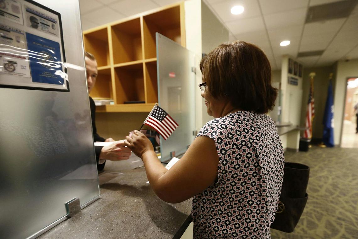  A woman receives a U.S. flag after passing her citizenship interview in Newark, N.J., on May 25, 2016. AP Photo/Julio Cortez 