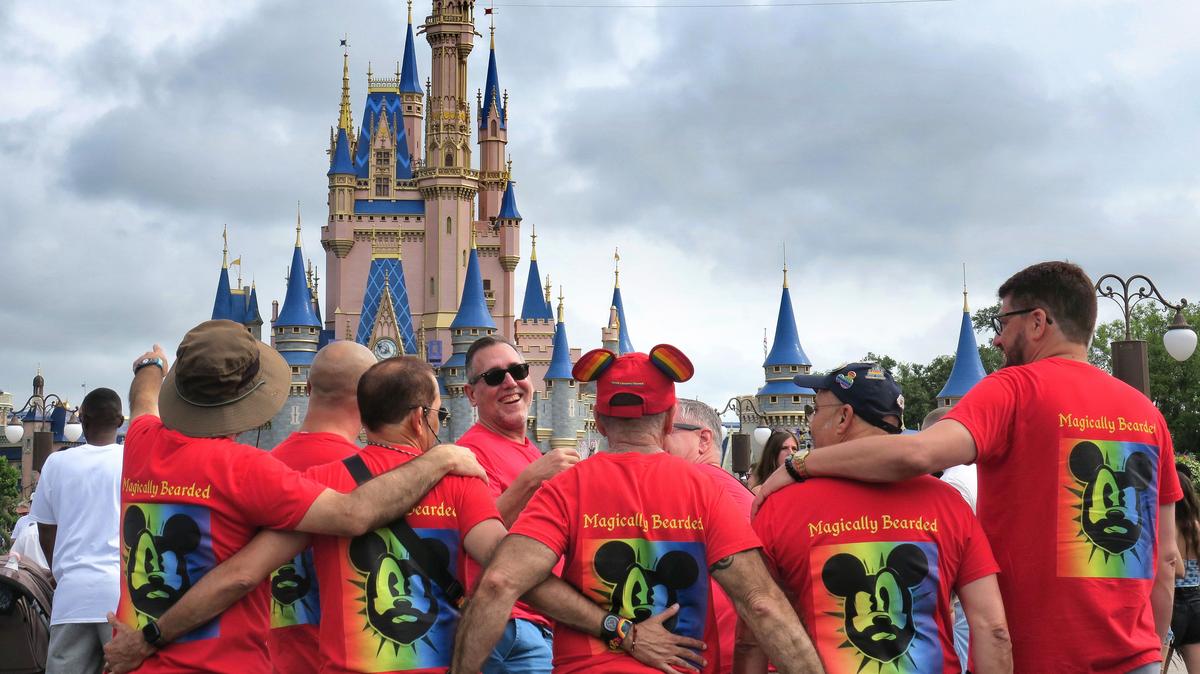 Guests visiting from St. Petersburg wear red shirts while gathering for a group picture at Cinderella Castle at the Magic Kingdom at Walt Disney World in 2023. (Joe Burbank/Orlando Sentinel)