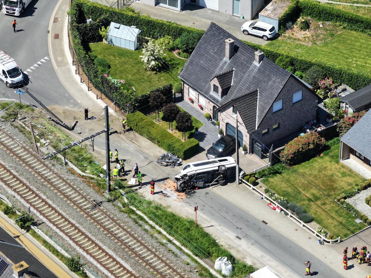 A drone view shows emergency personnel working near the damaged school bus that was struck by a train at a level crossing leading to multiple casualities, near the town of Buggenhout, Belgium, May 26, 2026. REUTERS/Bart Biesemans