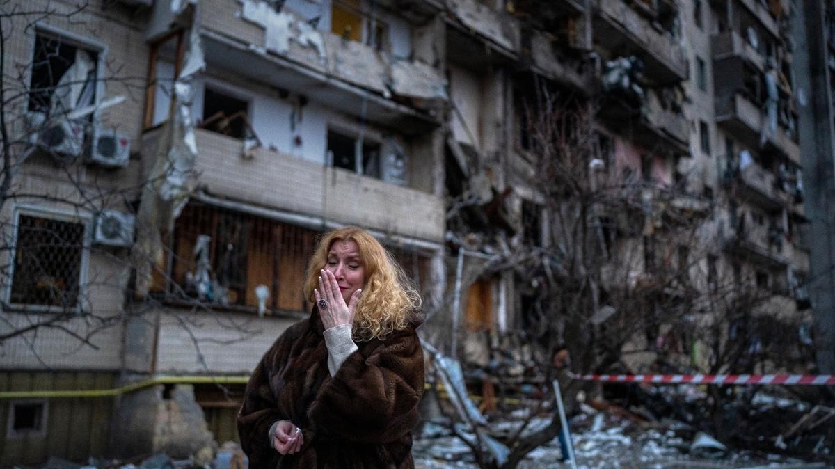 Archivo - Natali Sevriukova llora junto a su vivienda dañada después de un ataque con cohetes a la ciudad de Kiev, Ucrania, el 25 de febrero de 2022. La guerra de un año en Ucrania ha dejado decenas de miles de muertos y heridos en ambos bandos, ha interrumpido el suministro de energía y alimentos y ha reducido ciudades enteras a ruinas. (Foto AP/Emilio Morenatti, Archivo)