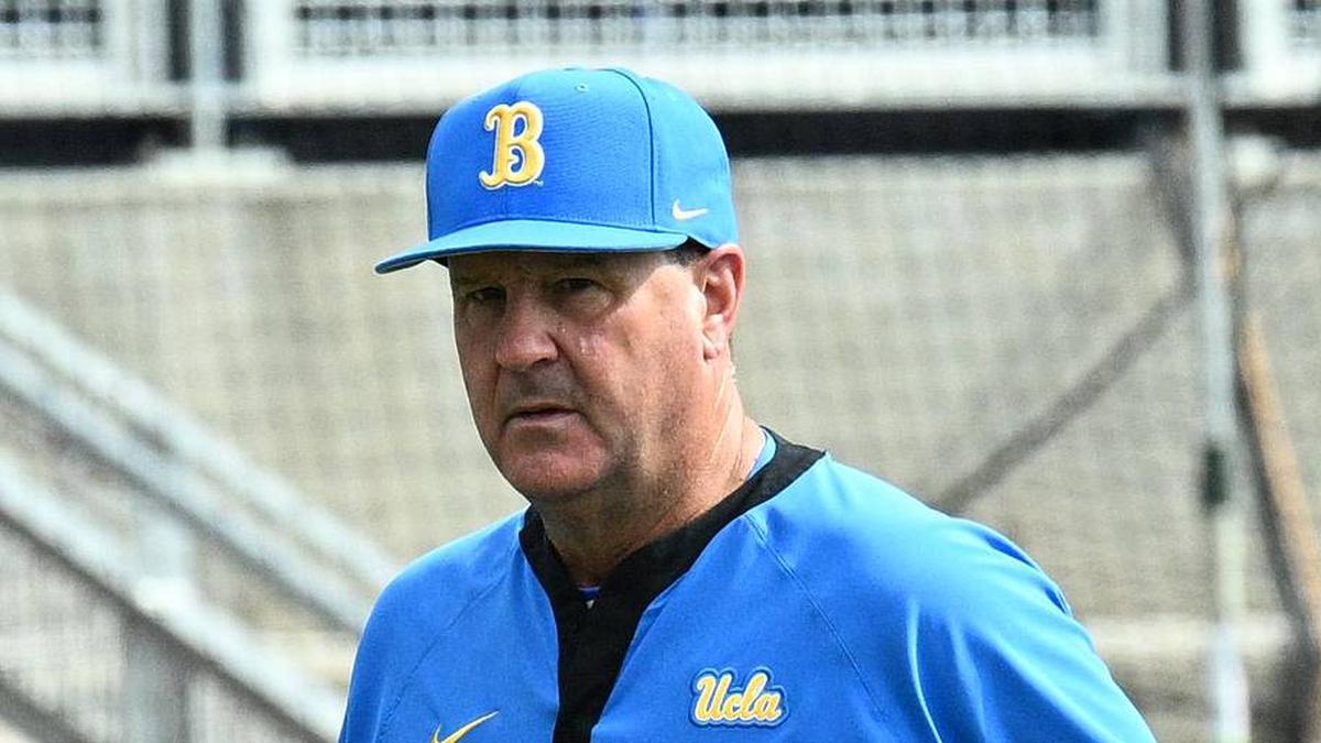 Jun 17, 2025; Omaha, Neb, USA; UCLA Bruins head coach John Savage (22) walks to the dugout before the restart of the game against the LSU Tigers at Charles Schwab Field. Mandatory Credit: Steven Branscombe-Imagn Images | Steven Branscombe-Imagn Images 