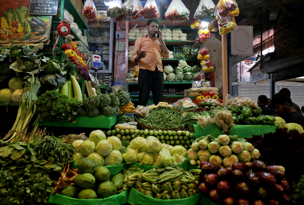 FILE PHOTO: Debashis Dhara, a vegetable vendor, speaks on his mobile phone at a retail market area in Kolkata, India, March 22, 2022. Picture taken March 22, 2022. REUTERS/Rupak De Chowdhuri/File Photo