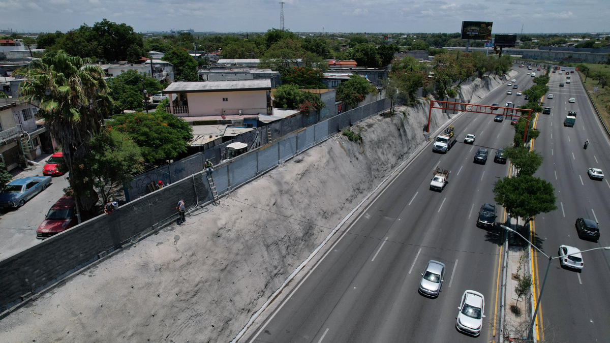 A drone view shows authorities erecting a wall along a road to one of the stadiums for the 2026 FIFA World Cup and airport to block poorer neighbourhoods from view, as many Mexicans say they feel excluded despite the tournament's return to the country, citing high ticket prices, paid television access and strict commercial restrictions, in Monterrey, Mexico, June 13, 2026. REUTERS/Daniel Becerril
