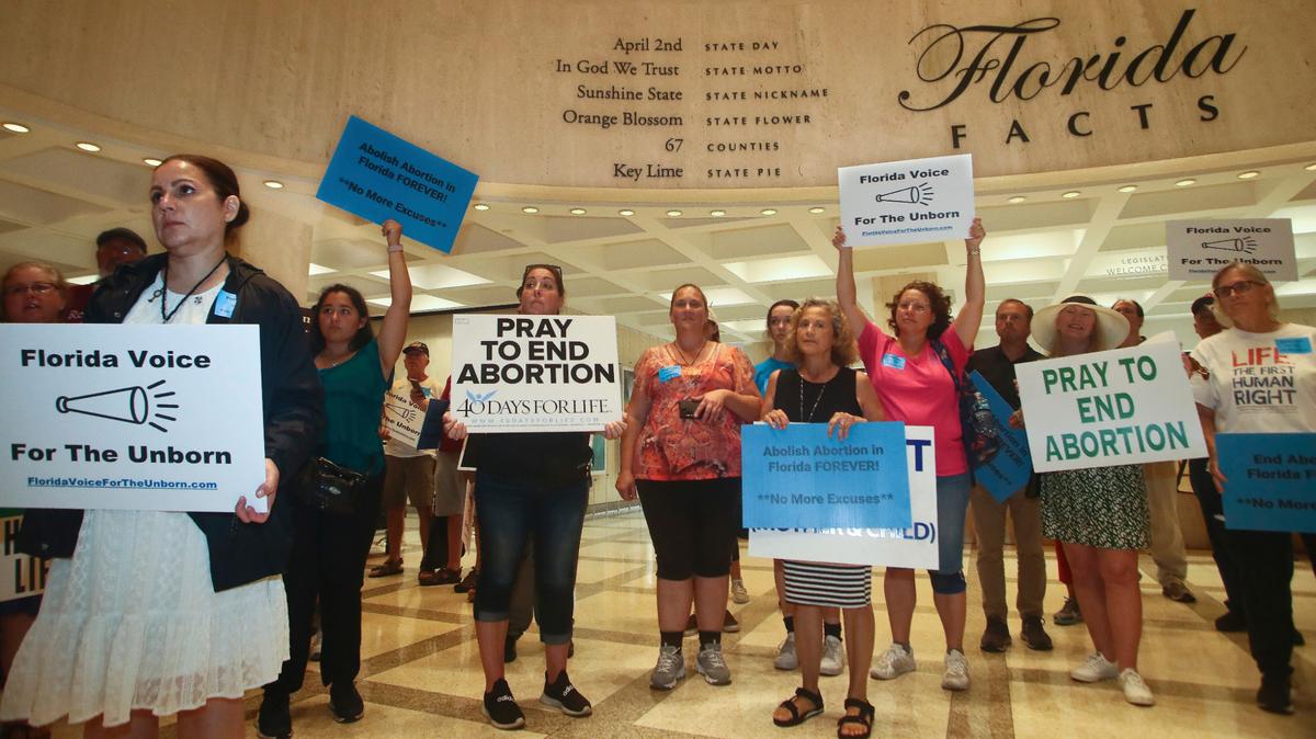 Partidarios de Florida Voice For The Unborn se manifiestan afuera del cuarto piso mientras los legisladores trabajan en proyectos de ley de seguros de propiedad, el martes 24 de mayo de 2022, en el Capitolio en Tallahassee, Florida.