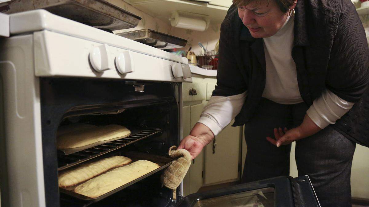 Laura Magone, the founder of Facebook’s Wedding Cookie Table Community, checks on a pan of biscotti cookies, baking in her mother's oven.