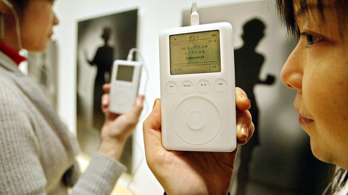Women use an iPod portable digital music player from Apple as they listen to an explanation of a contemporary Japanese art exhibition named "Roppongi Crossing" at the Mori Art Museum in Tokyo, Feb. 18, 2004.