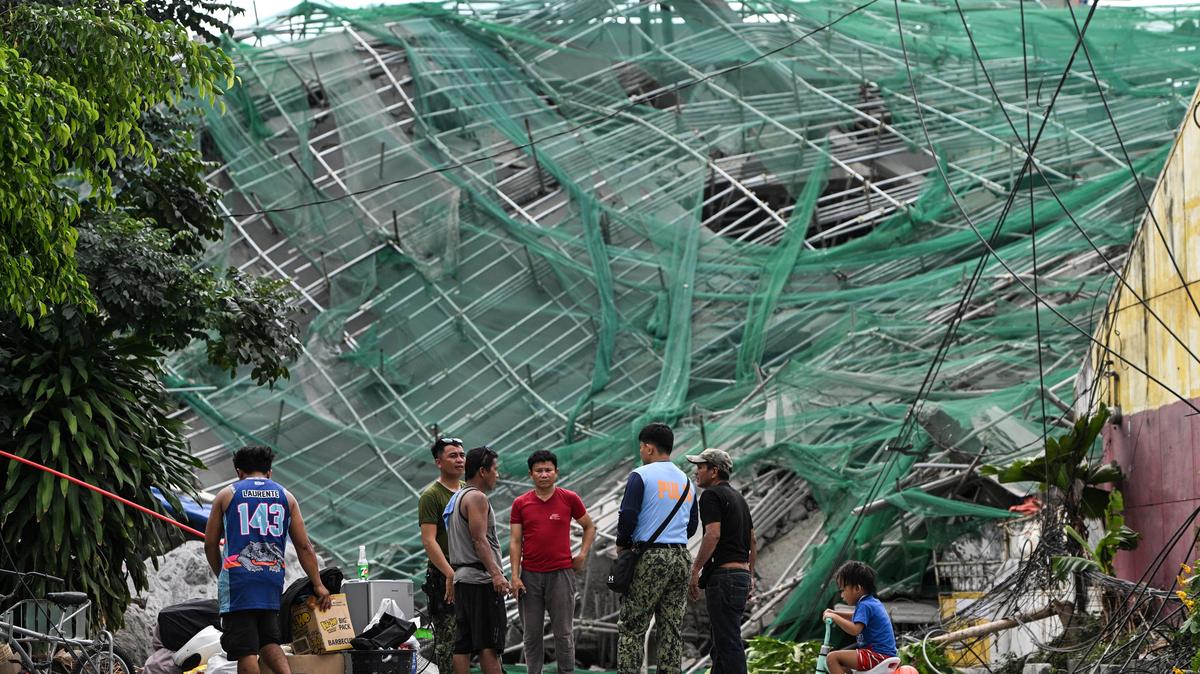 Policemen talk to workers as they leave their site accommodation at the foot of the nine-storey building that collapsed under construction in Balibago, Angeles City, Pampanga, Philippines, May 25, 2026. REUTERS/Noel Celis